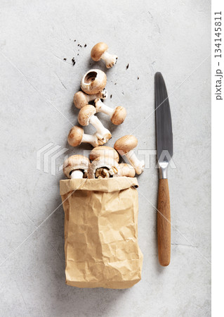Fresh Brown Mushrooms in a Paper Bag on Light Stone Background Fresh Brown Mushrooms in a Paper Bag on Light Stone Background 134145811