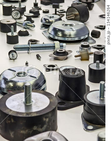Various metal and rubber parts are arranged on a table in a workshop for inspection and sorting Various metal and rubber parts are arranged on a table in a workshop for inspection and sorting 134146264