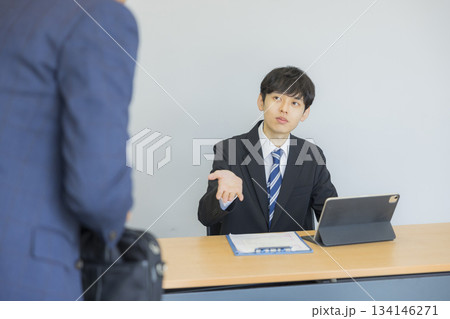 笑顔で話を聞くビジネスマン 笑顔で話を聞くビジネスマン 134146271