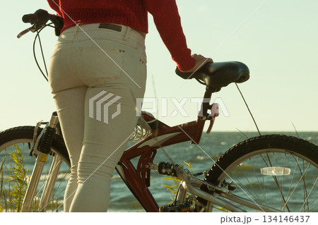 Unrecognizable woman bike cycling on sand 134146437