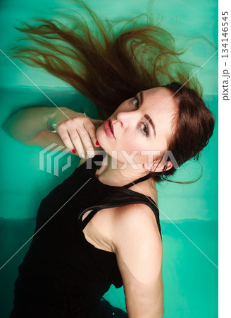 Sexy seductive woman in black dress in water. 134146545
