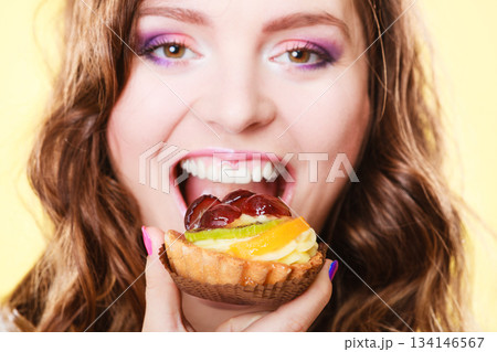 Closeup woman face and fruit cake Closeup woman face and fruit cake 134146567