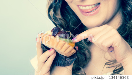 Smiling cute woman holds fruit cake in hand 134146568