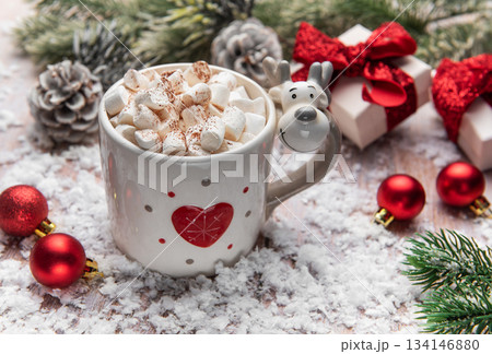 Reindeer mug holding hot chocolate with marshmallows in snow 134146880