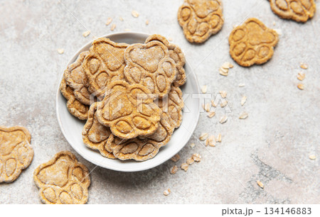 Paw print dog treats in bowl with oats 134146883