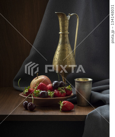 Elegant Still Life With Brass Pitcher, Fresh Fruit Bowl, Dark Draped Backdrop, Studio Lighting Elegant Still Life With Brass Pitcher, Fresh Fruit Bowl, Dark Draped Backdrop, Studio Lighting 134148031