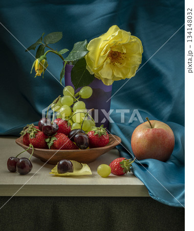 Vibrant Still Life With Yellow Rose, Fruit Bowl, Grapes, Berries, and Apple on Blue Silk Fabric 134148032