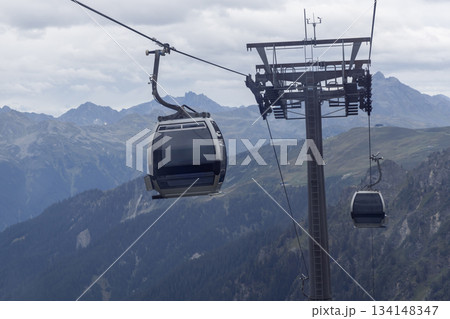 Gargellen cable cars transport visitors above Montafon valley in Vorarlberg, Austria during sunny weather in the summer months 134148347
