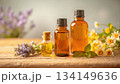 エッセンシャルオイル瓶とハーブ・花素材／木のテーブル・自然光・アロマ・ボタニカル 134149636