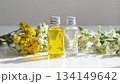 精油ボトルと黄色・白色の小花／明るい自然光・ナチュラル・クリーンなイメージ 134149642