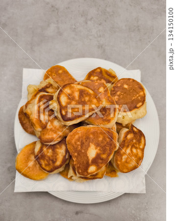 Freshly cooked pancakes resting on a white plate Freshly cooked pancakes resting on a white plate 134150100