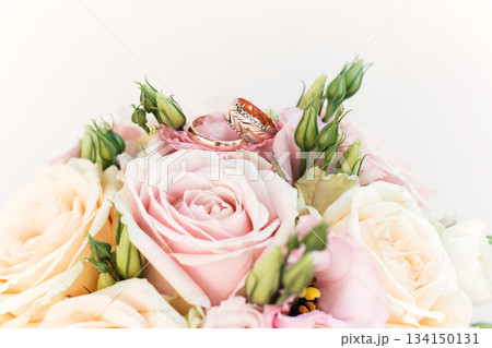 Wedding rings resting on a bouquet of pink and white roses Wedding rings resting on a bouquet of pink and white roses 134150131