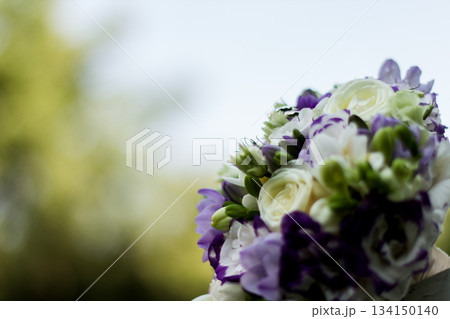 Wedding bouquet combining white roses and purple freesias 134150140
