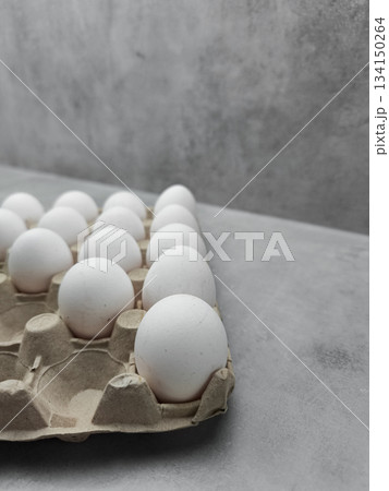 Carton of white eggs resting on gray surface easter 134150264