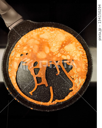 Bunny shaped pancake cooking in frying pan for maslenitsa or shrove tuesday breakfast 134150294