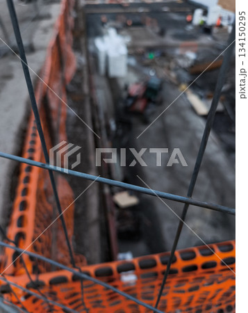 Construction site viewed through orange safety netting vysocany 134150295