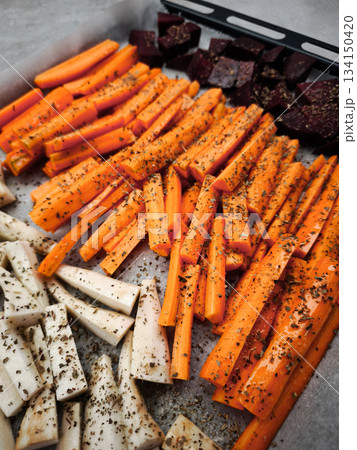 Chopped carrots, parsnips and beetroots with herbs and spices ready for roasting healthy dinner snacks 134150420