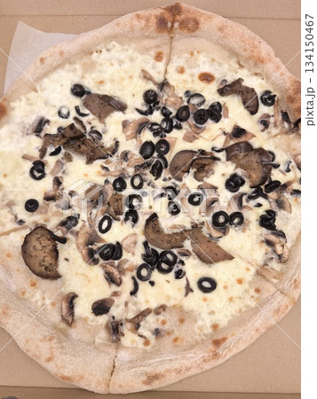 Delicious pizza with mushrooms and black olives in cardboard box Delicious pizza with mushrooms and black olives in cardboard box 134150467