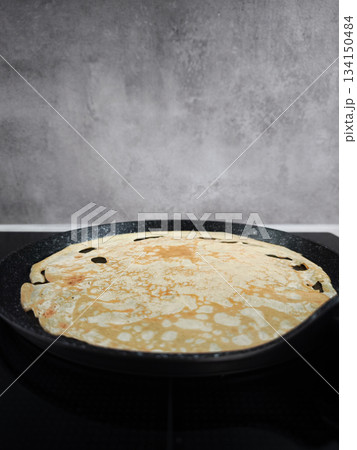 Cooking crepe on frying pan for shrove tuesday, maslenitsa or breakfast celebration 134150484