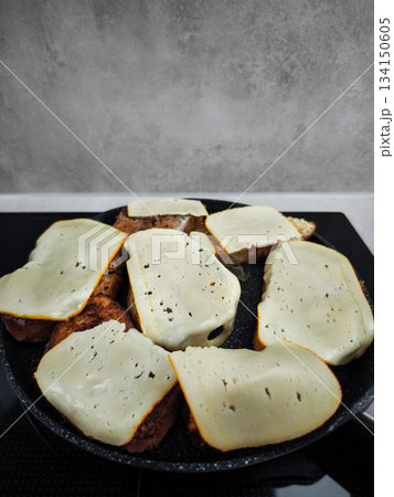Slices of cheese melting on toasted bread in frying pan for breakfast Slices of cheese melting on toasted bread in frying pan for breakfast 134150605
