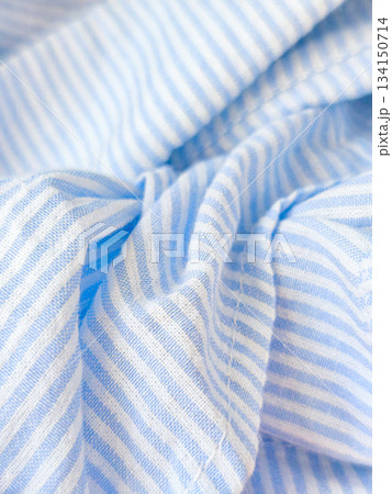 Soft blue and white striped fabric gently folded 134150714