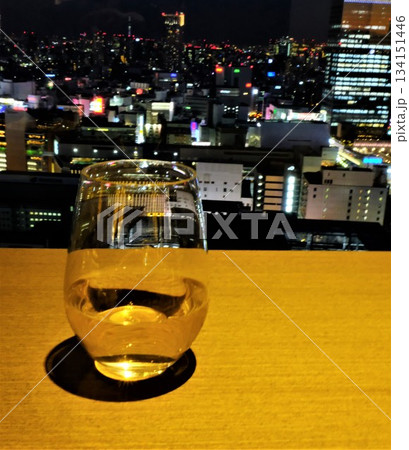 大都市の夜景を背景にした白ワインが入ったグラスの情景 134151446