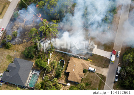 Wildfire rages near homes in Florida town while fire trucks and emergency crew combat the advancing flames 134152661