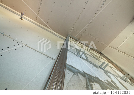 Unfinished brick wall in a room under construction prepared for drywall plates frame installation. 134152823