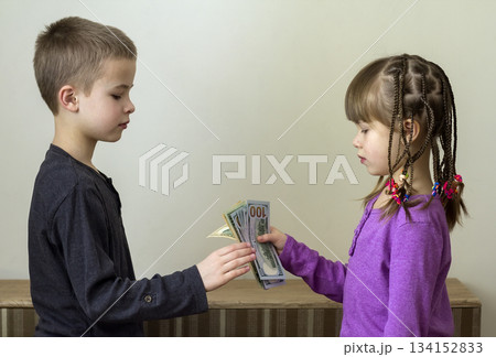 Two little children boy and girl playing with dollars money. 134152833