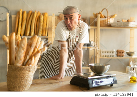 Humorous portrait of fan male baker with a sieve on his head 134152941