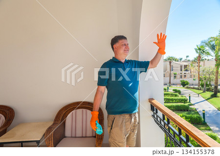 Happy Man on His Balcony Joyfully Greeting Neighbors, Embracing Community Spirit and Connection in a Bright, Welcoming Home Environment 134155378