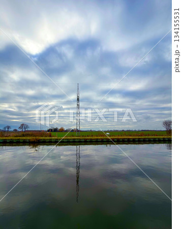 Rijkevorsel, Antwerpse Kempen, Belgium, Tall transmission structure mirrored beneath quiet canal Rijkevorsel, Antwerpse Kempen, Belgium, Tall transmission structure mirrored beneath quiet canal 134155531
