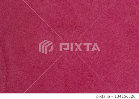Textured leather surface in bold Lava red color with fine natural grain and vibrant tone. Natural background for fashion design, trend focused palettes and statement styling 134156320