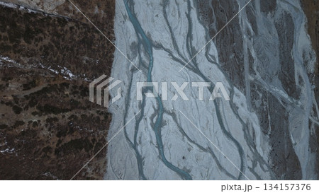 Aerial view of glacial river patterns on rocky terrain with textures 134157376