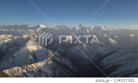 Snow-covered mountain range under clear blue sky with dramatic peaks 134157383