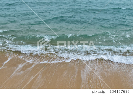 Close-up of soft waves sand beach and blue sea. Texture of water, white foam waves. Seascape, Sea background, Sea water with copy space, summer vacation concept. Close-up of soft waves sand beach and blue sea. Texture of water, white foam waves. Seascape, Sea background, Sea water with copy space, summer vacation concept. 134157653