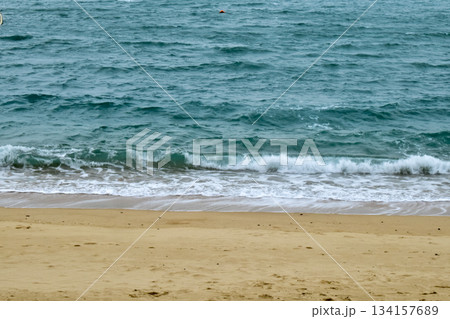 Close-up of soft waves sand beach and blue sea. Texture of water, white foam waves. Seascape, Sea background, Sea water with copy space, summer vacation concept. Close-up of soft waves sand beach and blue sea. Texture of water, white foam waves. Seascape, Sea background, Sea water with copy space, summer vacation concept. 134157689