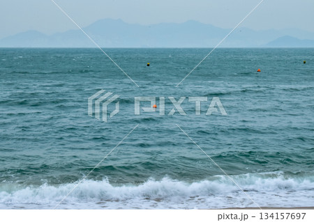 Close-up of soft waves sand beach and blue sea. Texture of water, white foam waves. Seascape, Sea background, Sea water with copy space, summer vacation concept. Close-up of soft waves sand beach and blue sea. Texture of water, white foam waves. Seascape, Sea background, Sea water with copy space, summer vacation concept. 134157697