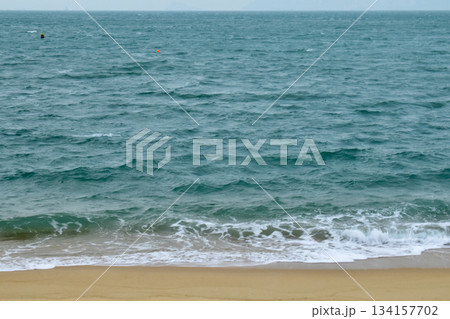 Close-up of soft waves sand beach and blue sea. Texture of water, white foam waves. Seascape, Sea background, Sea water with copy space, summer vacation concept. Close-up of soft waves sand beach and blue sea. Texture of water, white foam waves. Seascape, Sea background, Sea water with copy space, summer vacation concept. 134157702
