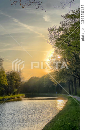 A Tranquil Sunset Over a Serene River Surrounded by Lush Green Trees and Nature A Tranquil Sunset Over a Serene River Surrounded by Lush Green Trees and Nature 134158183