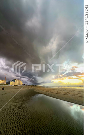 Nieuwpoort, West-Vlaanderen, Belgium, Ocotber 25th, 2025, Lone figures walk beneath turbulent skies Nieuwpoort, West-Vlaanderen, Belgium, Ocotber 25th, 2025, Lone figures walk beneath turbulent skies 134158243