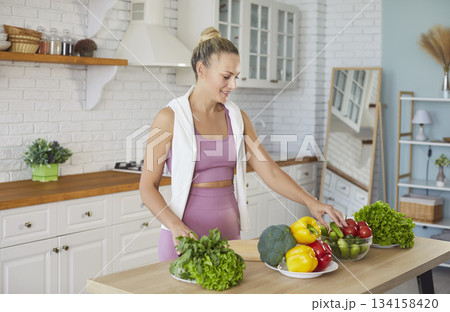 Healthy diet for strong fit young woman, happy athlete cooking salad before training at home 134158420