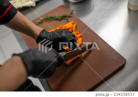 Male cook chopping fresh vegetables during food preparation Male cook chopping fresh vegetables during food preparation 134158537