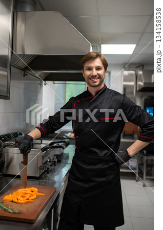 Male cook chopping fresh vegetables 134158538