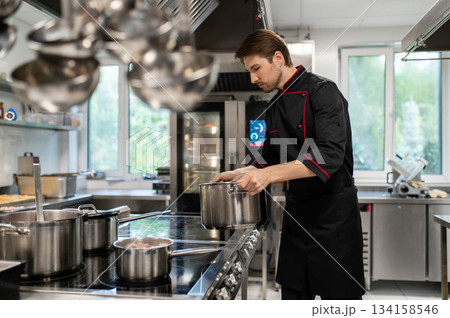Male culinary chef working in restaurant workspace Male culinary chef working in restaurant workspace 134158546