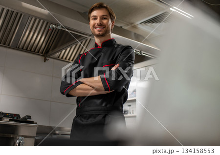 Professional chef standing in modern kitchen 134158553