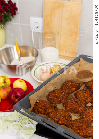 Liver cutlets rest on a tray on a balcony surrounded by autumn flowers. Nearby are apples, a bowl of sugar, eggs, and flour, indicating cooking activity in the city Liver cutlets rest on a tray on a balcony surrounded by autumn flowers. Nearby are apples, a bowl of sugar, eggs, and flour, indicating cooking activity in the city 134158730