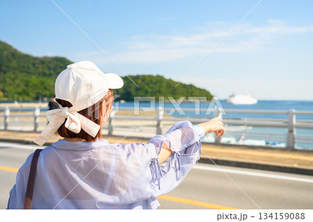 港で海を指差す女性 134159088