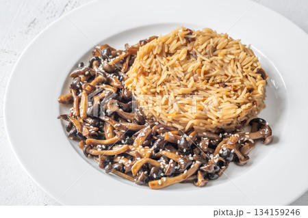 Savory fried rice topped with umami Shimeji mushrooms and golden sunny egg Savory fried rice topped with umami Shimeji mushrooms and golden sunny egg 134159246