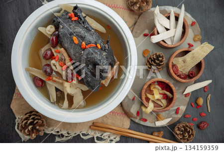Widely celebrated in Chinese and Asian culinary traditions, the nourishing health stew pictured is known as "Black Chicken Soup" or "silkie chicken soup". 134159359